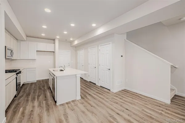 a kitchen with a sink and wooden floor