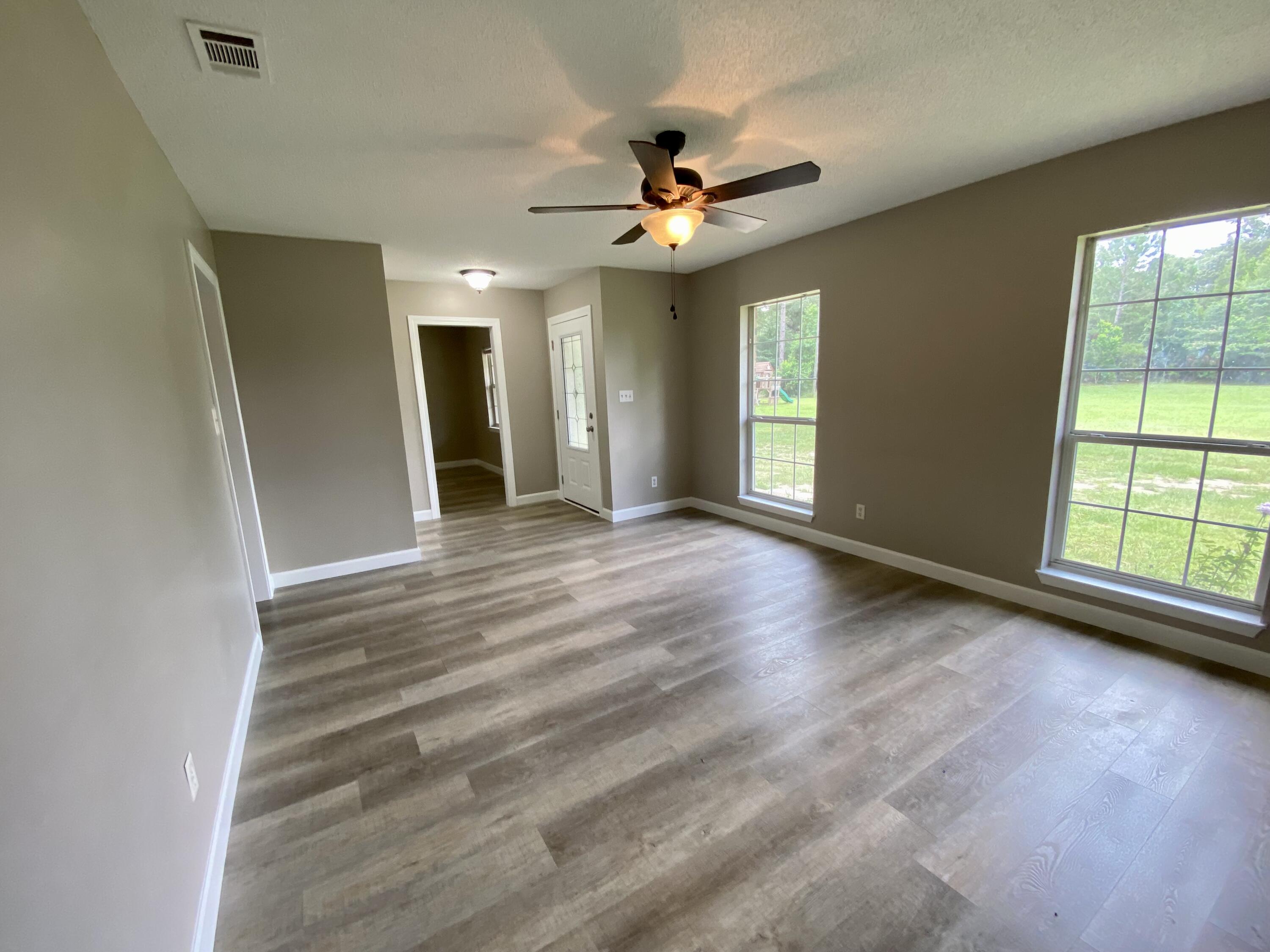 3517 Auburn Road Crestview, FL 32539 - Photo 5 of 22 a view of an empty room with window and wooden floor