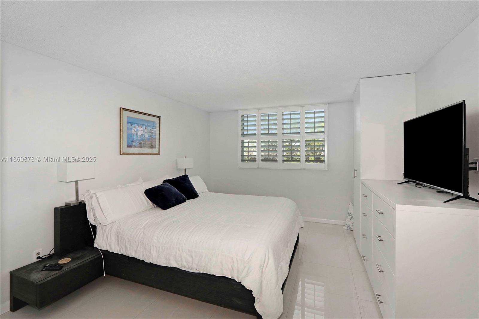 210 Seaview Drive, Unit 207 Key Biscayne, FL 33149 - Photo 12 of 24 a bedroom with a bed and a flat screen tv