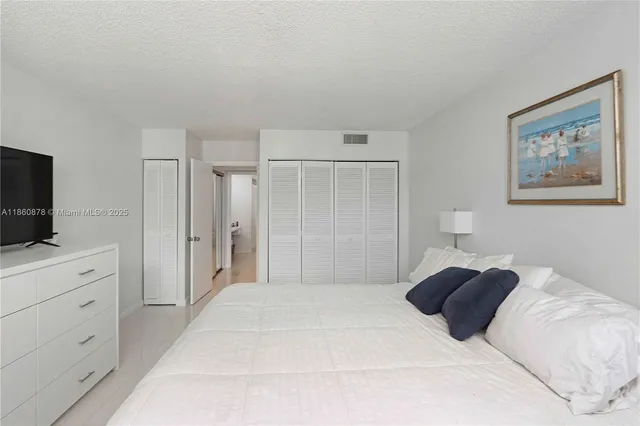 a bedroom with a large bed and a flat screen tv