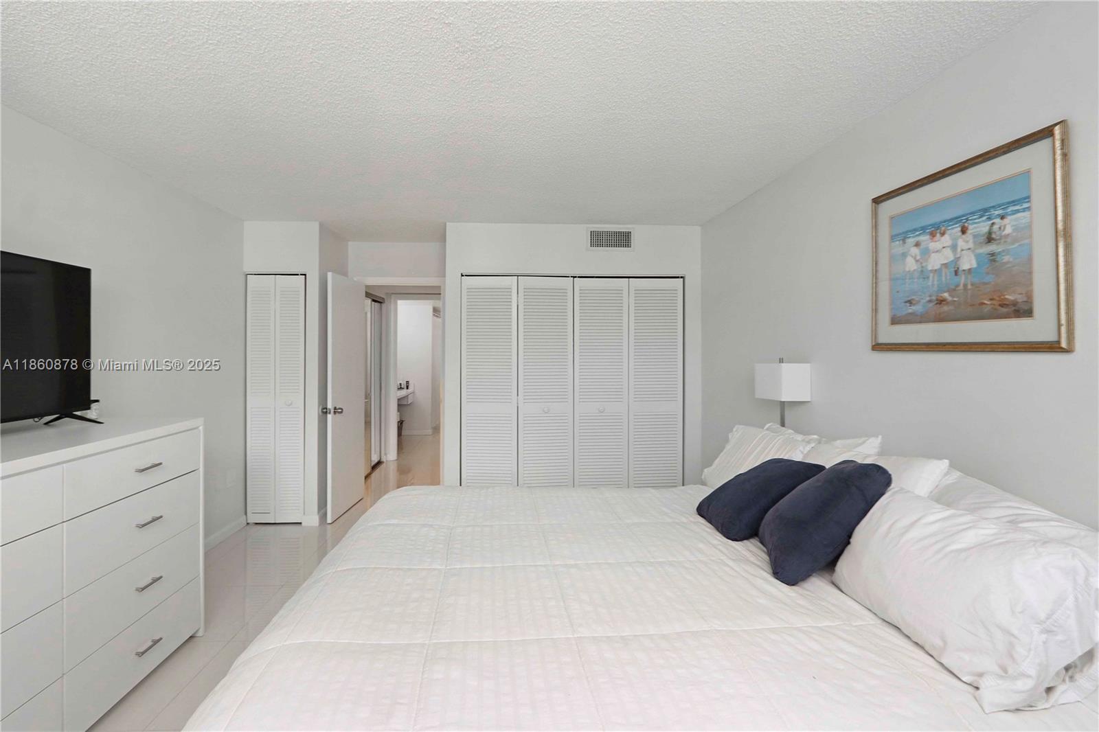 210 Seaview Drive, Unit 207 Key Biscayne, FL 33149 - Photo 13 of 24 a bedroom with a large bed and a flat screen tv
