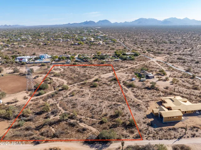 an aerial view of residential houses with outdoor space and trees