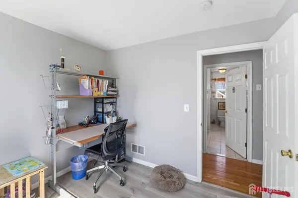 a view of a workspace with furniture and wooden floor