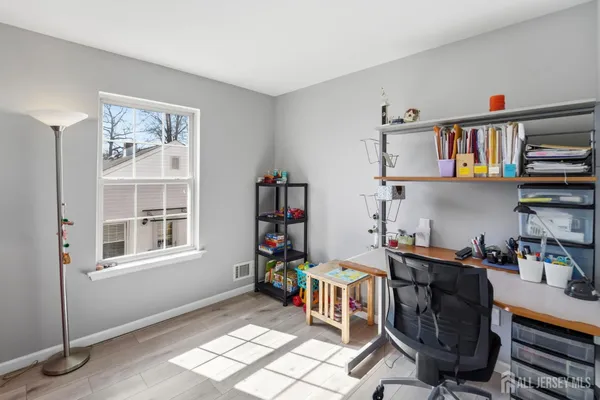 a view of a workspace with furniture and a window