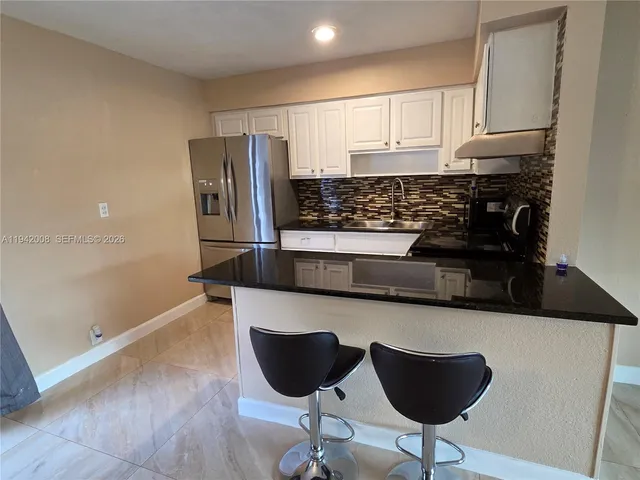 a kitchen with stainless steel appliances granite countertop a refrigerator and a stove top oven