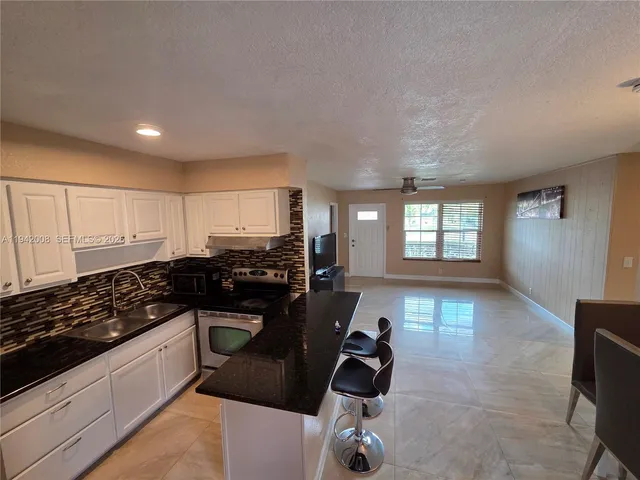 a kitchen with sink refrigerator and stove