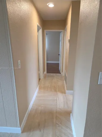 a view of a hallway with wooden floor and closet