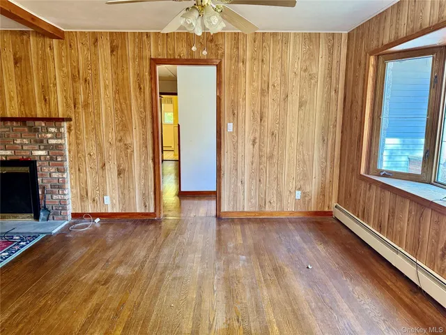 a view of a room with wooden floor stairs and a fireplace