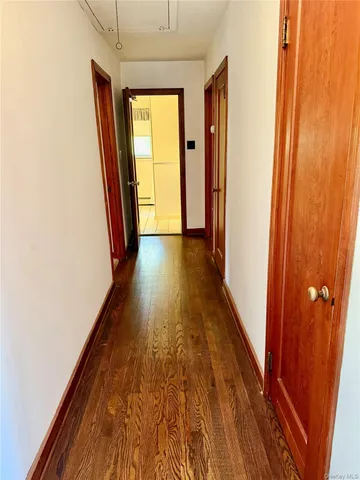 a view of hallway with wooden floor and stairs