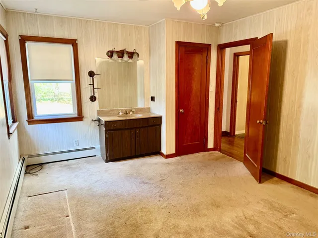 a view of an empty room with window and bathroom