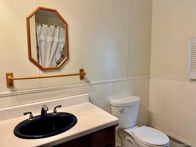 a bathroom with a sink a toilet and a mirror
