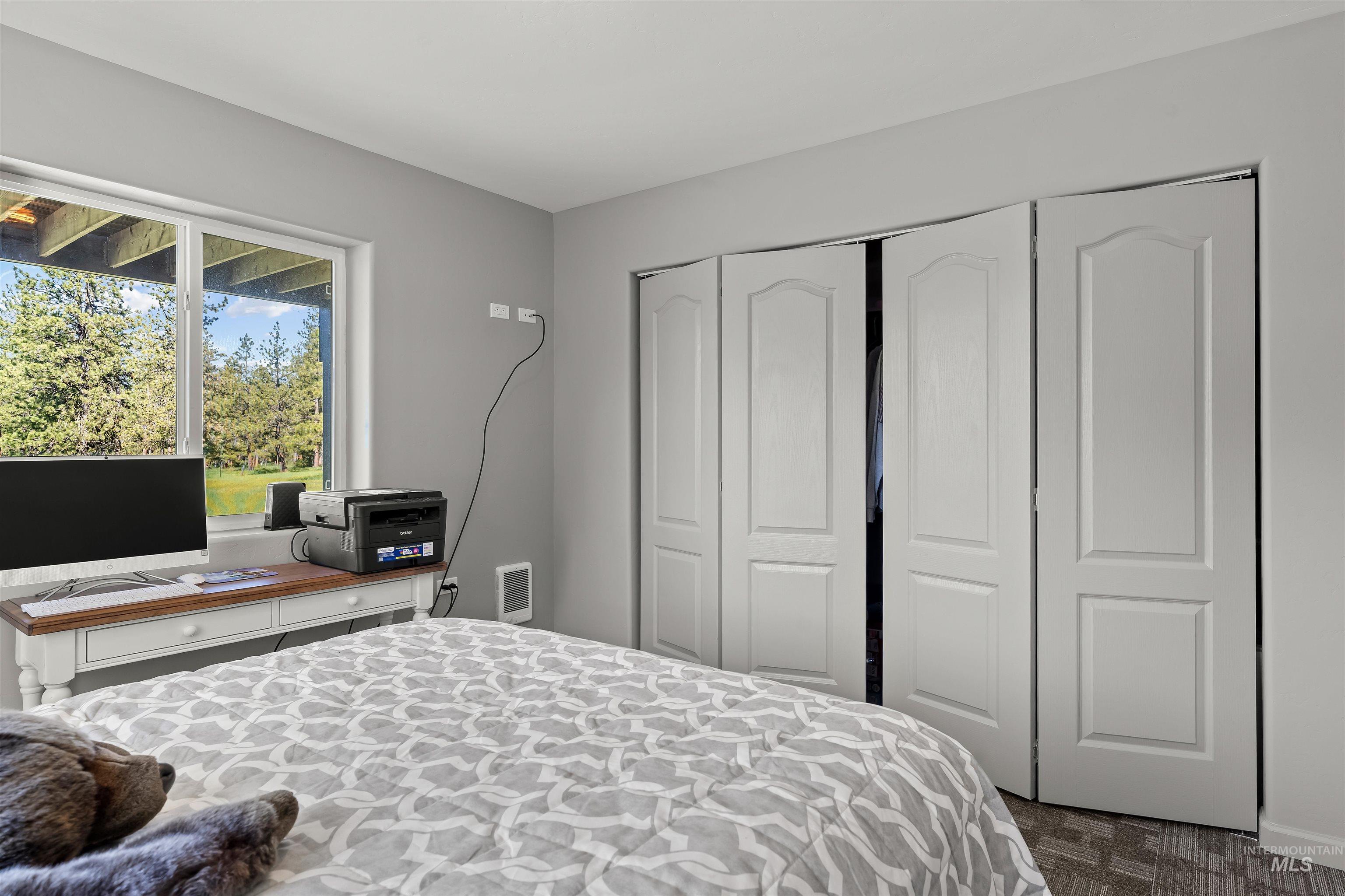 507 Bearlea Road Anatone, WA 99401 - Photo 18 of 47 Interior room featuring a large window, bi-fold closet doors, and light gray wall paint
