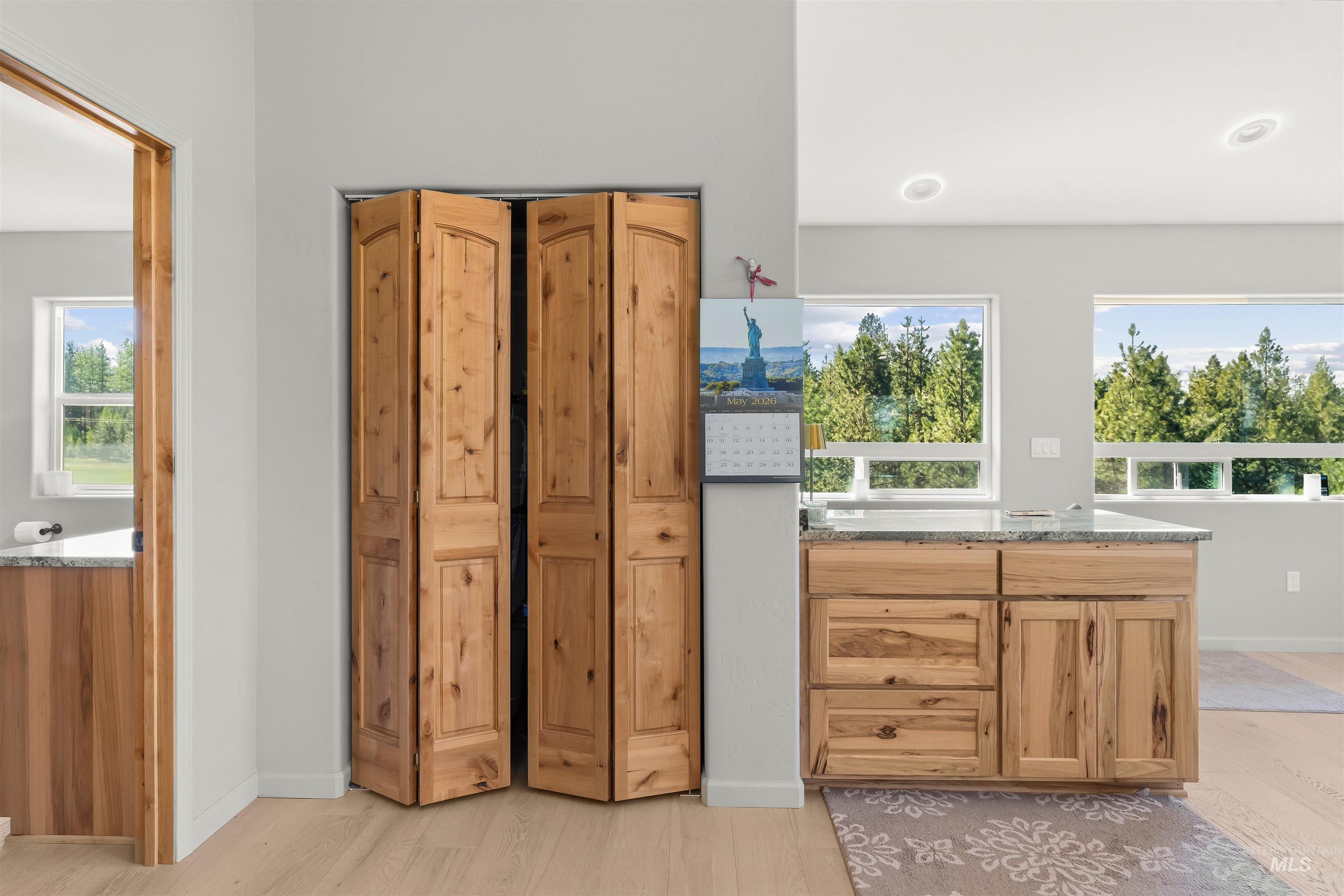 507 Bearlea Road Anatone, WA 99401 - Photo 23 of 47 Light wood-finish bi-fold doors, wood-finish flooring, recessed lighting, and multiple windows showcasing surrounding trees