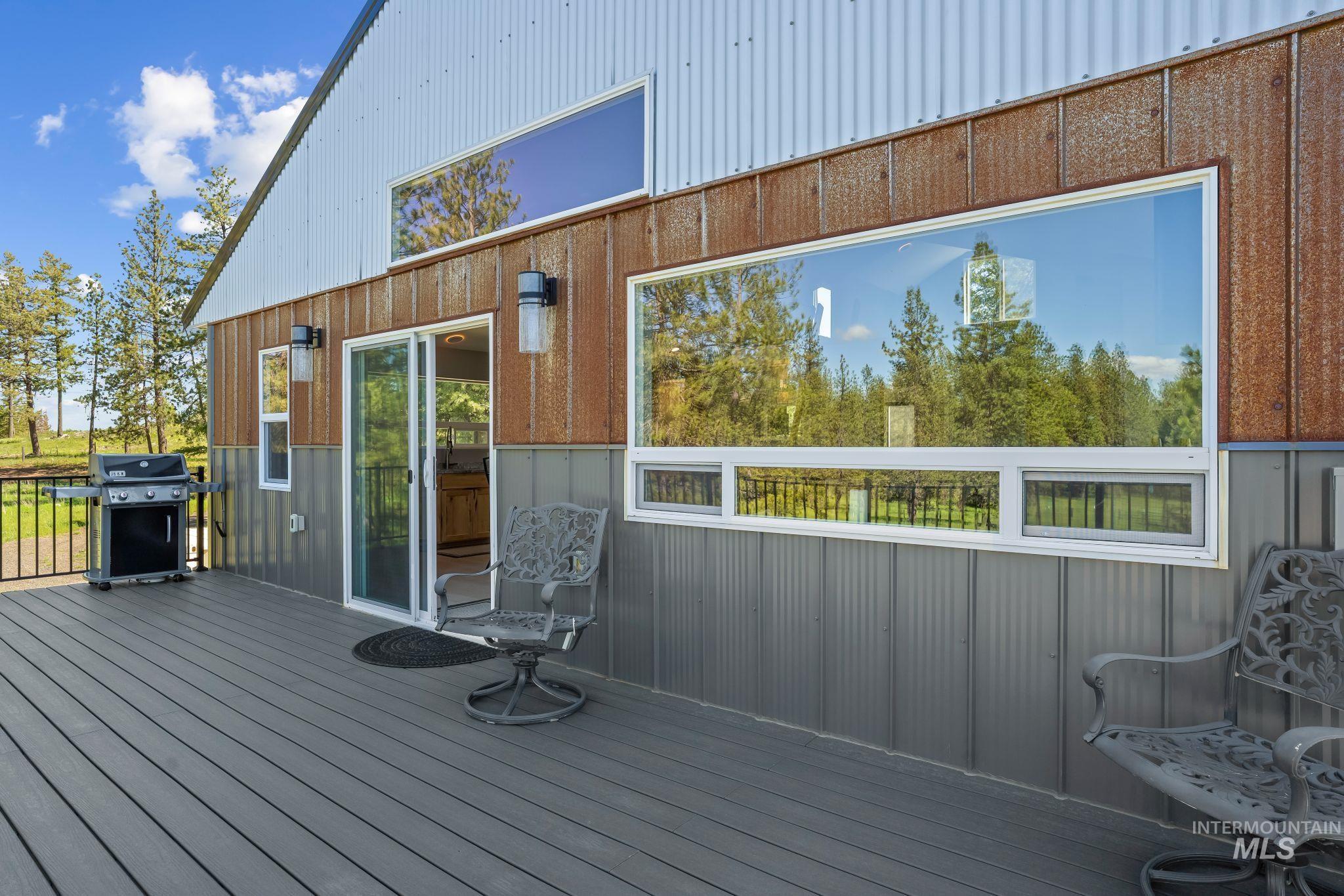 507 Bearlea Road Anatone, WA 99401 - Photo 28 of 47 Expansive outdoor deck featuring dark composite decking, a black metal railing, and direct access to the interior via a sliding glass door