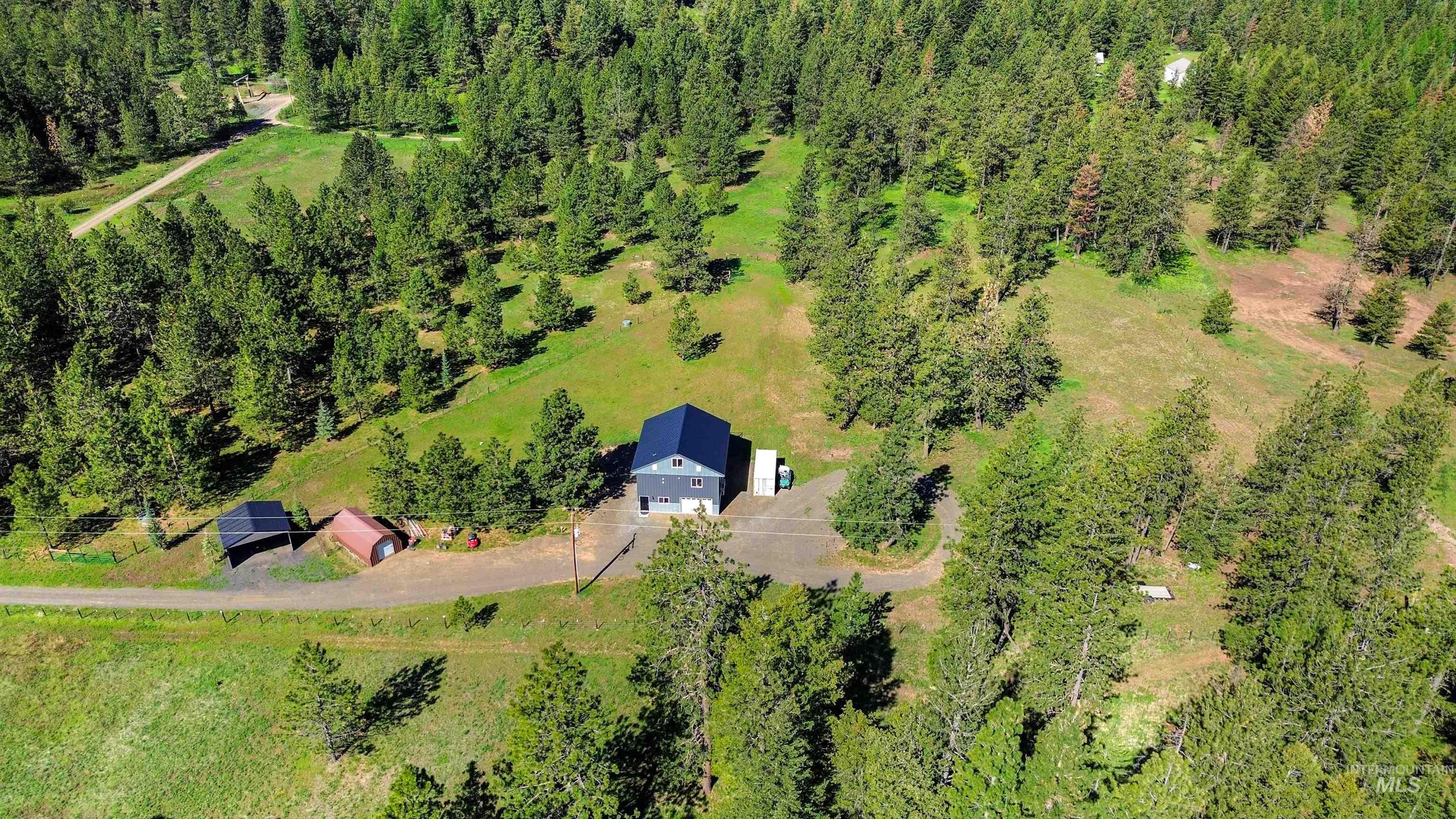 507 Bearlea Road Anatone, WA 99401 - Photo 41 of 47 Modern farmhouse style residence with a dark blue metal roof, light gray siding, and a paved driveway