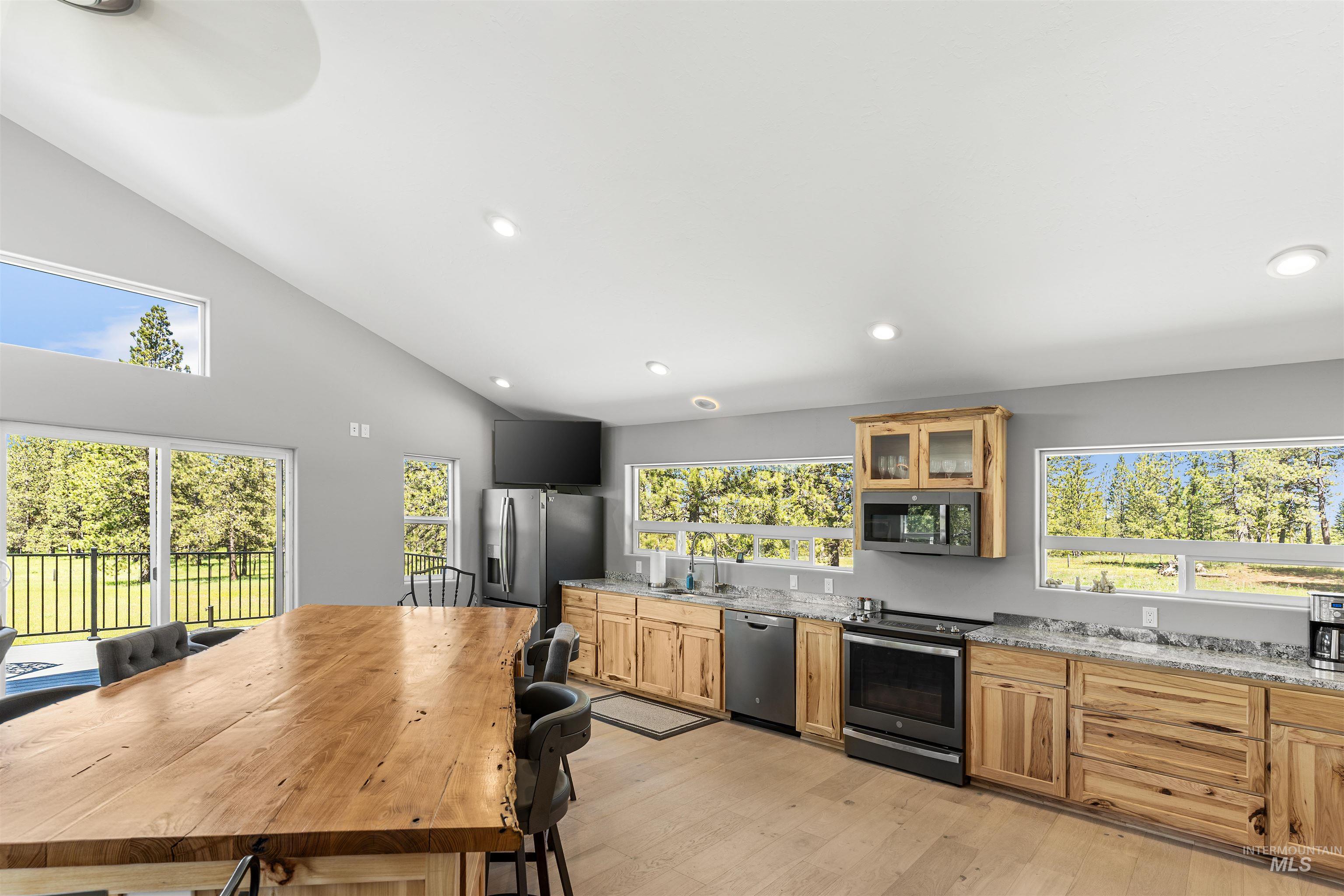 507 Bearlea Road Anatone, WA 99401 - Photo 5 of 47 Vaulted ceiling kitchen featuring wood-finish flooring, light wood cabinetry, stainless steel appliances, and Granite countertops