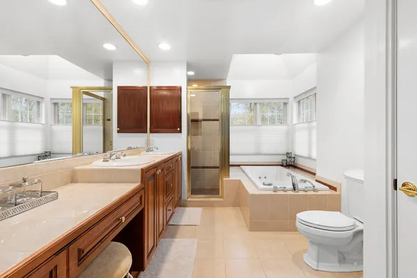 a bathroom with a granite countertop sink a toilet a mirror and bathtub