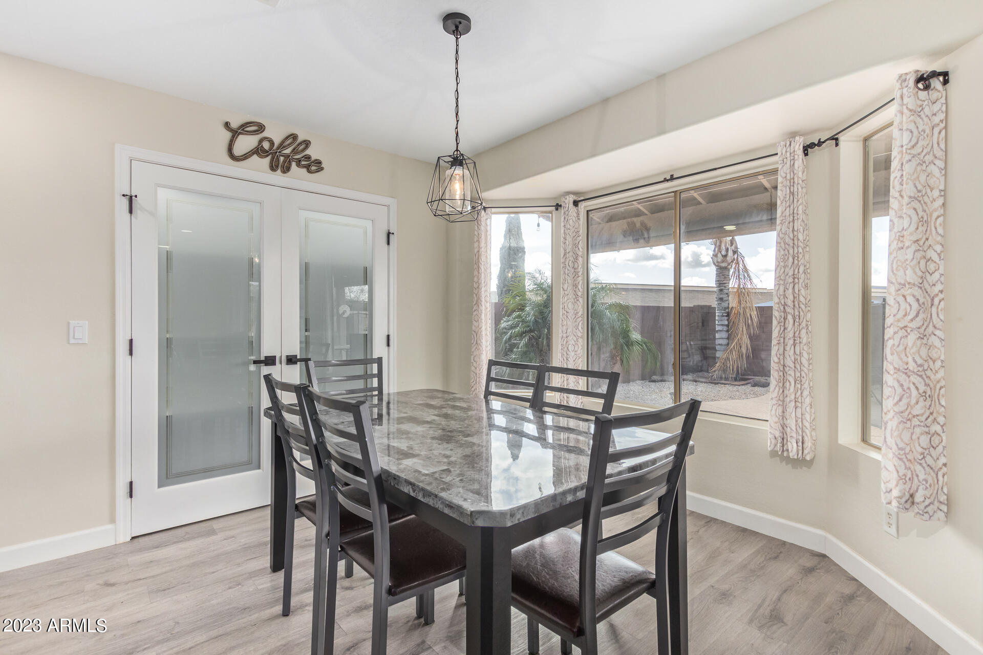 2561 West Tanner Ranch Road Queen Creek, AZ 85144 - Photo 11 of 36 a view of a dining room with furniture window and wooden floor