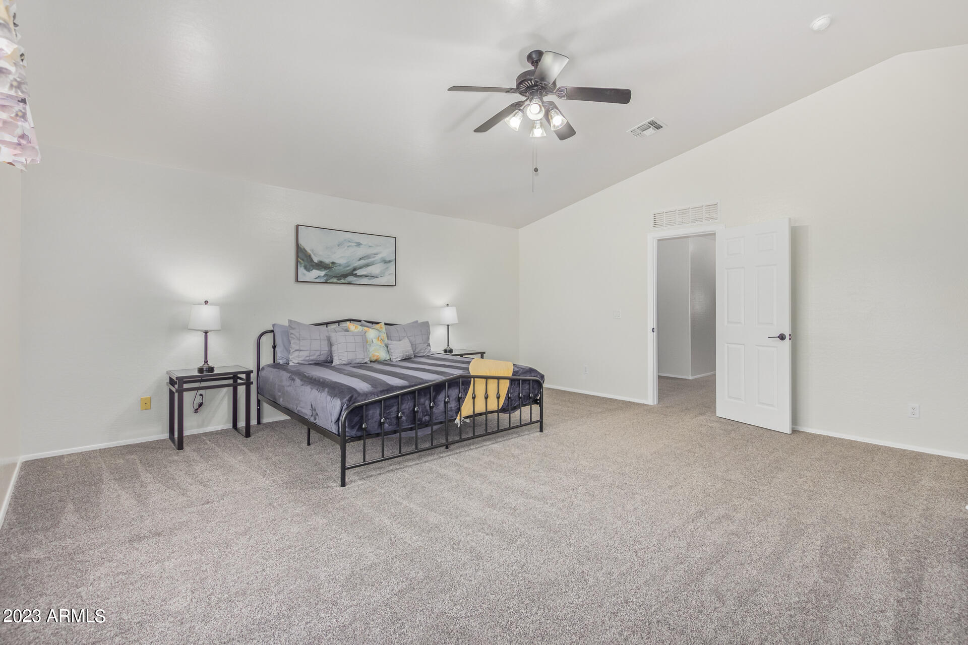 2561 West Tanner Ranch Road Queen Creek, AZ 85144 - Photo 20 of 36 a spacious bedroom with a bed and a chandelier