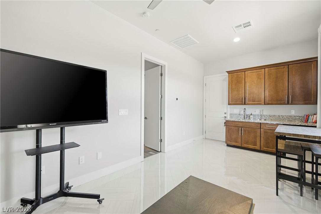45 Garibaldi Way Henderson, NV 89011 - Photo 3 of 74 Bright white flooring extends through this room, complete with a functional wet bar.