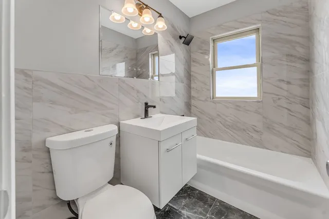 a bathroom with a sink a toilet a mirror and bathtub