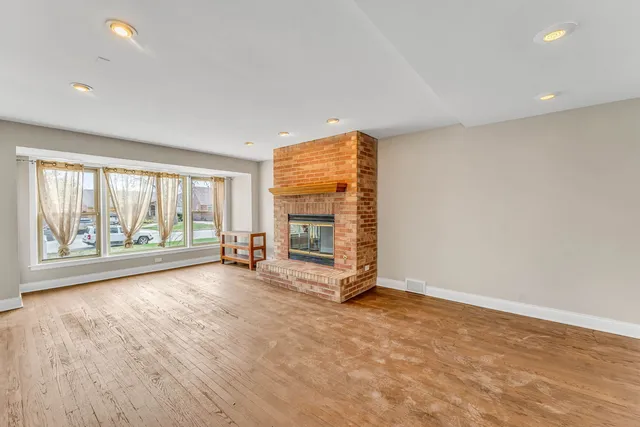 a view of an empty room with a fireplace and a window