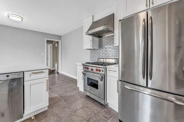 a kitchen with white cabinets and stainless steel appliances