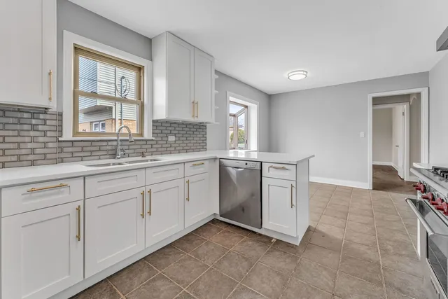 a kitchen with a stove a sink and a window