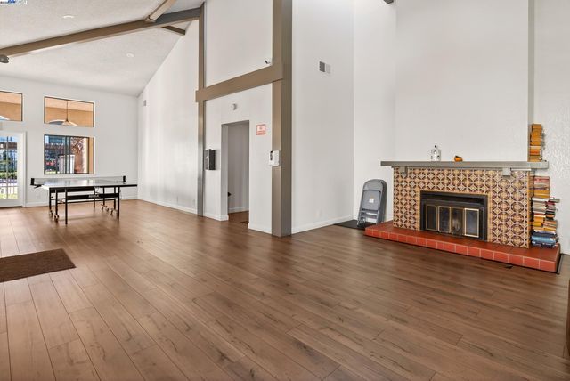 a view of a livingroom with wooden floor and a fireplace