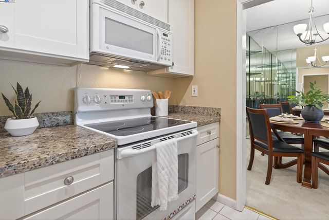 a kitchen with granite countertop a sink and white cabinets