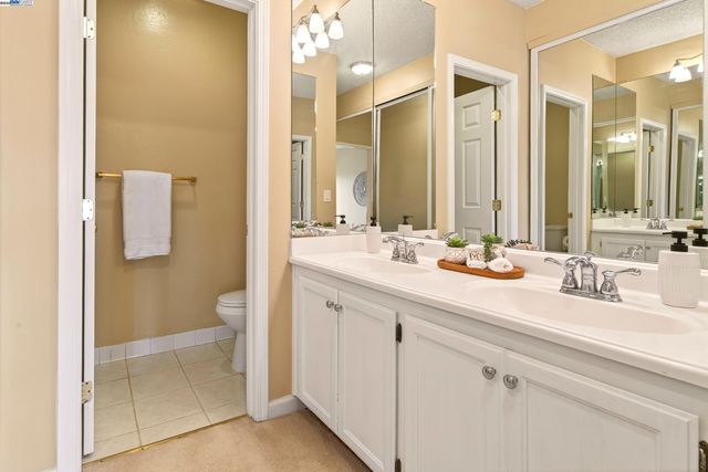 a bathroom with a sink a toilet and a mirror