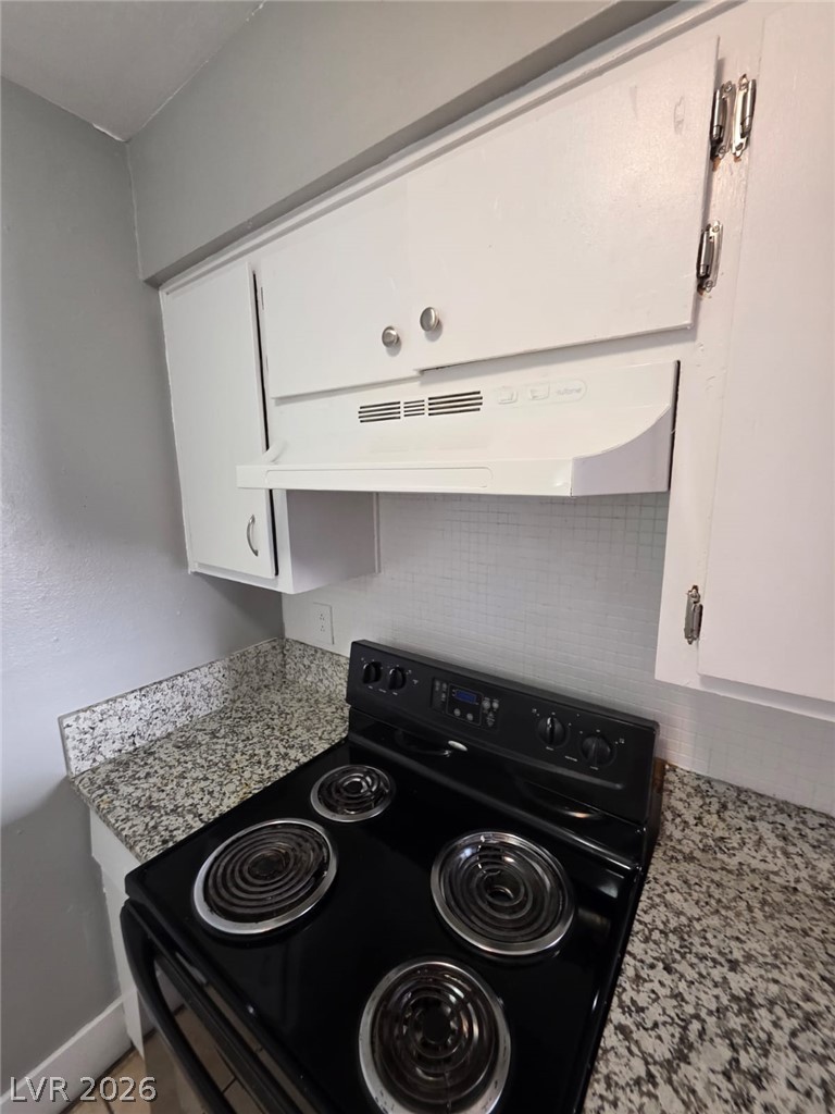 1075 East Desert Inn Road, Unit 2 Las Vegas, NV 89109 - Photo 7 of 13 Functional kitchen design features stone countertops and classic cabinetry alongside modern cooking appliances.