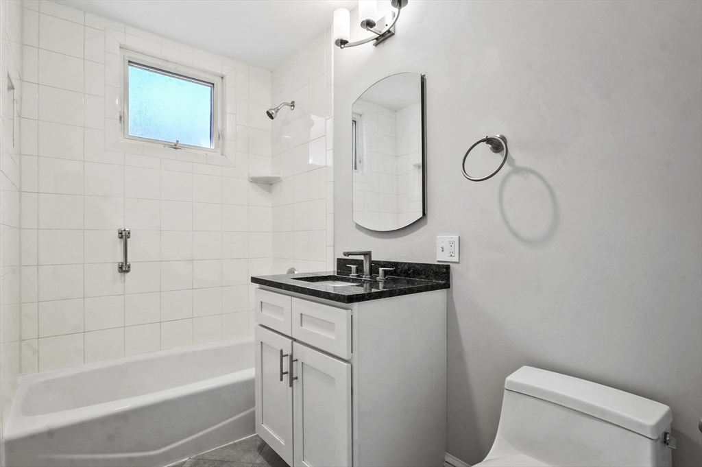 91 Verndale Street, Unit 2 Brookline, MA 02446 - Photo 14 of 18 a bathroom with a granite countertop sink a toilet and shower
