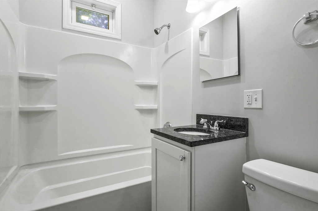 91 Verndale Street, Unit 2 Brookline, MA 02446 - Photo 15 of 18 a bathroom with a granite countertop sink and a toilet
