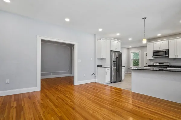 a view of kitchen with stainless steel appliances granite countertop a refrigerator and a stove top oven