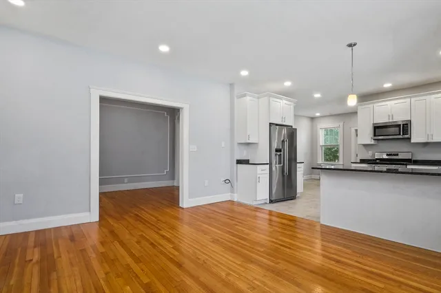 a view of kitchen with stainless steel appliances granite countertop a refrigerator and a stove top oven