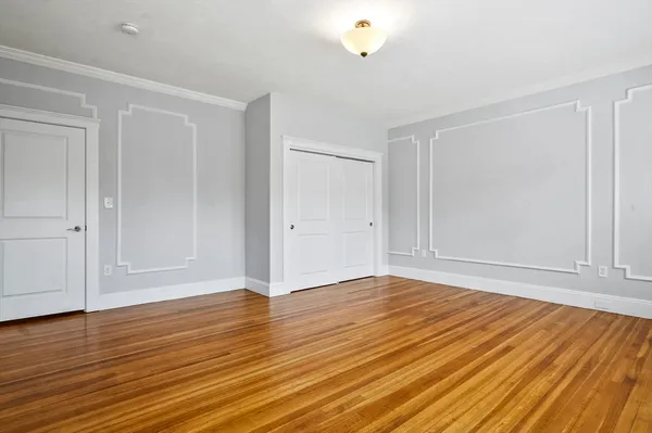 a view of an empty room with wooden floor