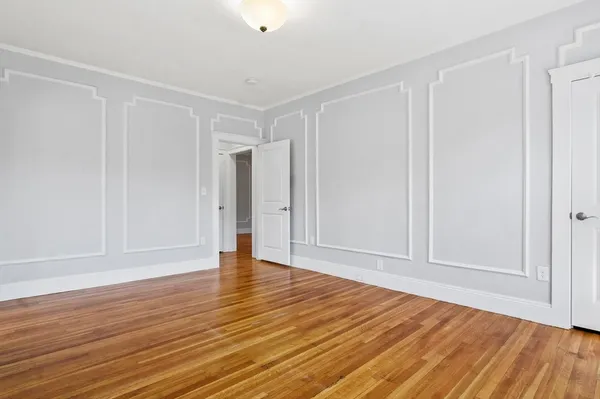 a view of an empty room with wooden floor