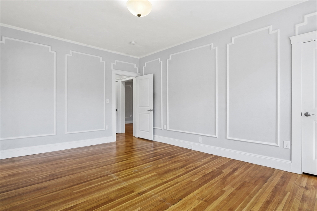 91 Verndale Street, Unit 2 Brookline, MA 02446 - Photo 10 of 18 a view of an empty room with wooden floor