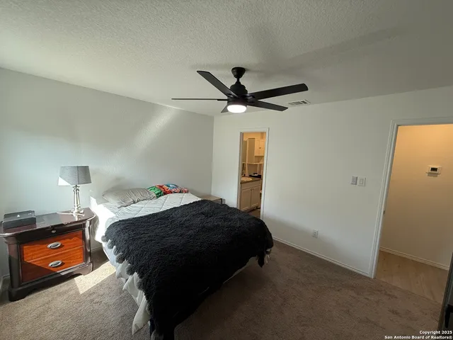 a bedroom with a bed and a ceiling fan