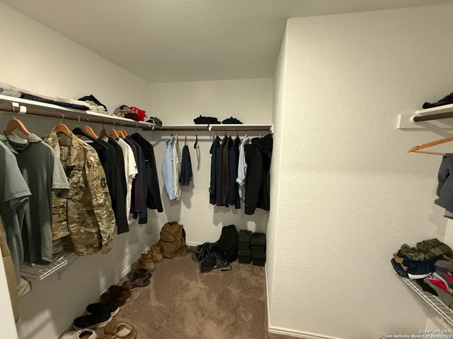 a view of walk in closet with clothes and shoes