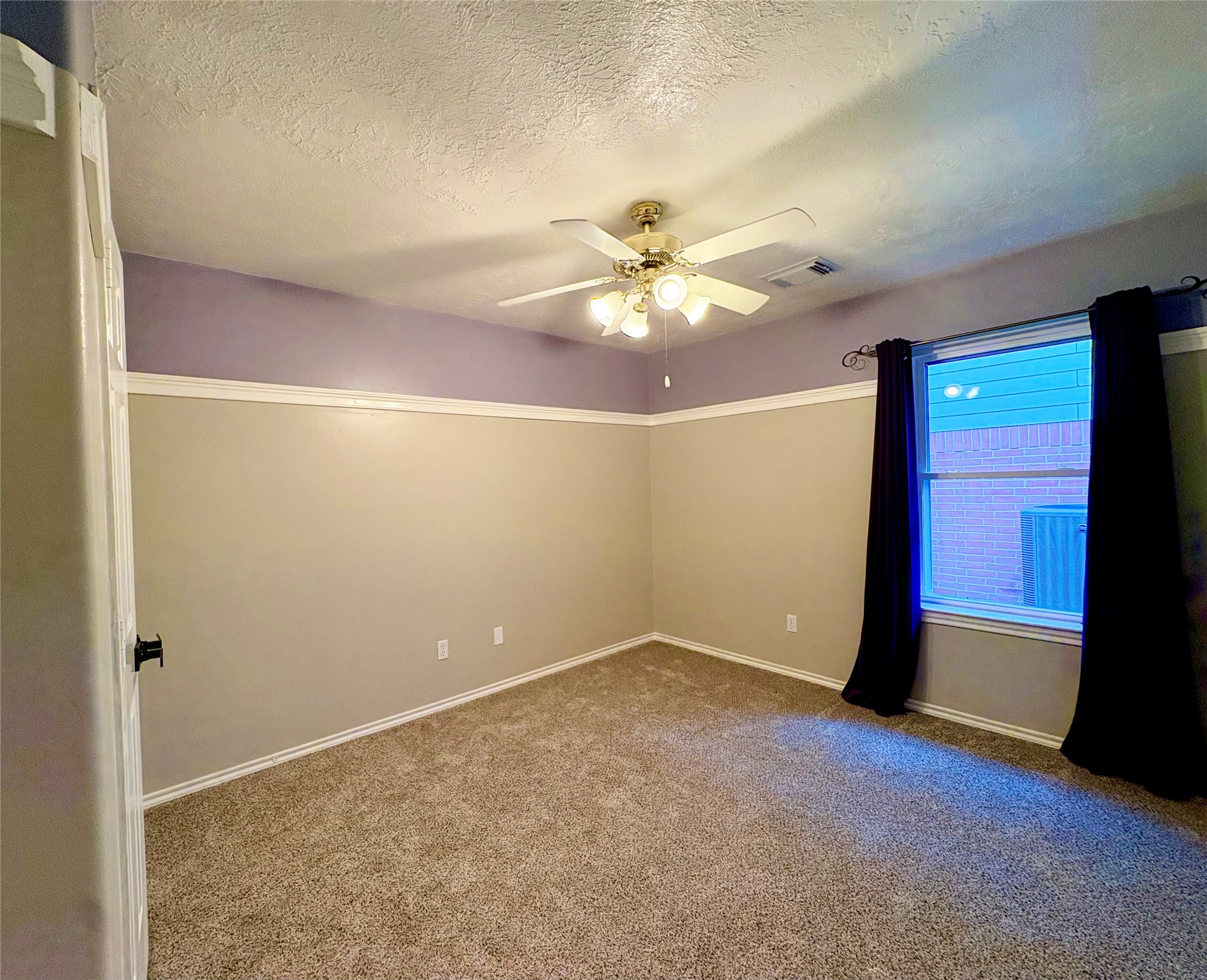 15410 Redbud Berry Way Cypress, TX 77433 - Photo 38 of 49 This room features neutral walls with a purple accent, plush carpet, and a ceiling fan. It has a window with dark curtains, providing natural light and a cozy ambiance.