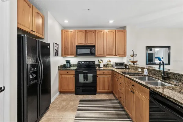 a kitchen with stainless steel appliances granite countertop a refrigerator and a sink