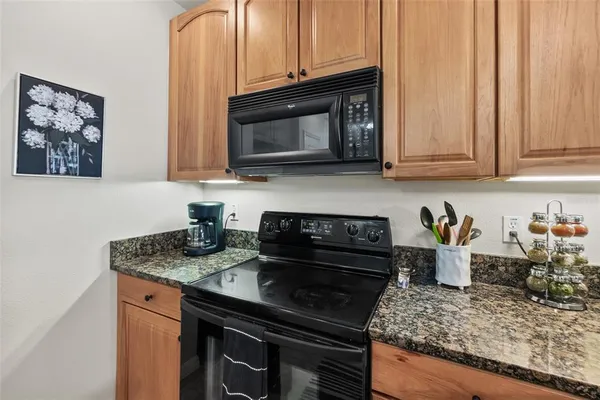 a kitchen with stainless steel appliances granite countertop a stove microwave and cabinets