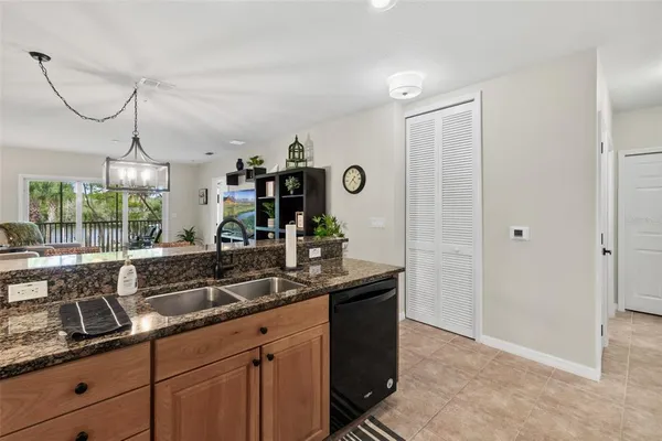 a dining hall with granite countertop a sink and white cabinets
