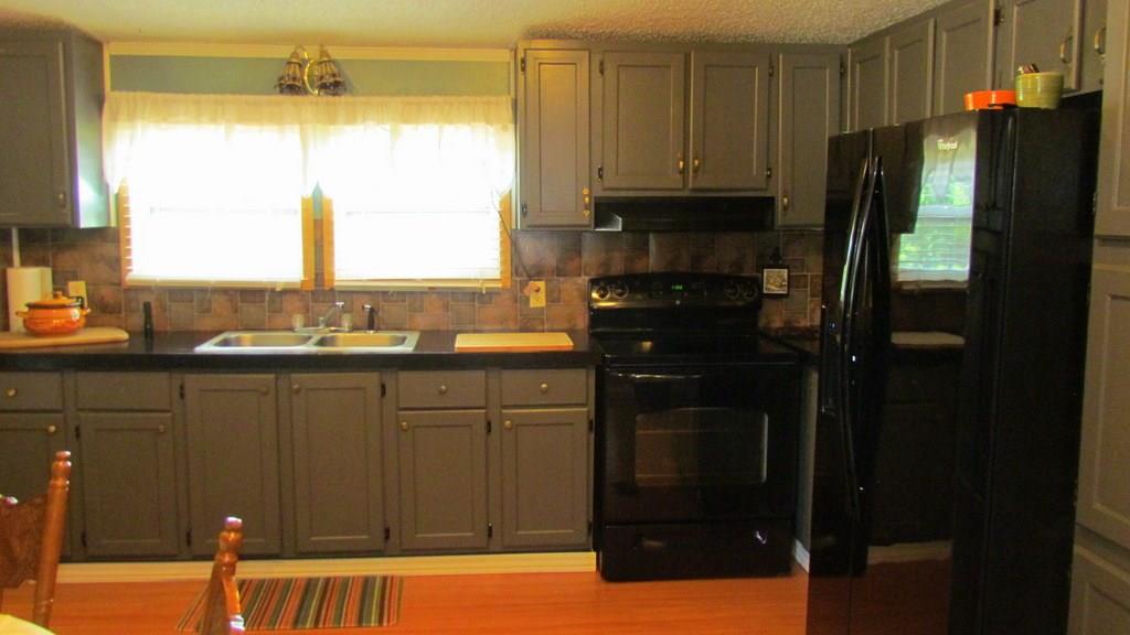 1317 Poole Gooden Road Hiddenite, NC 28636 - Photo 17 of 36 a kitchen with a refrigerator a stove a sink and a window