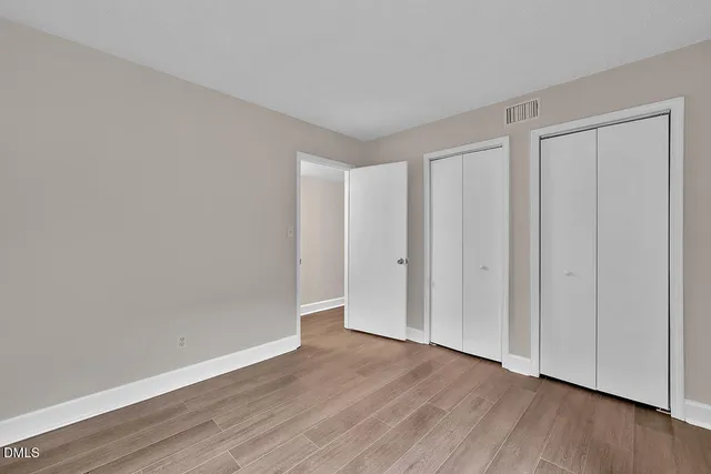 a view of an empty room with wooden floor