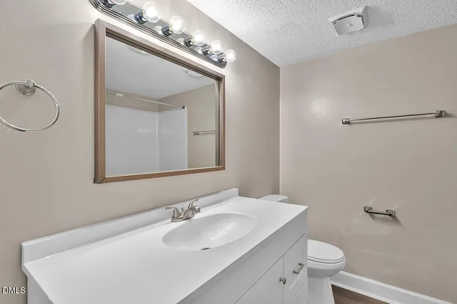 a bathroom with a sink a toilet and mirror