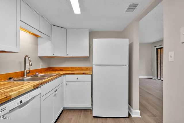 a kitchen with a refrigerator sink and cabinets