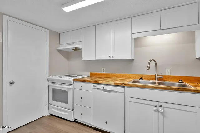 a kitchen with white cabinets and sink